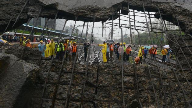 Railway and rescue workers gather around a site where a portion of a pedestrian footbridge collapsed over a railway track in Mumbai, Maharashtra in July 3, 2018. (Punit Paranjpe / AFP)
