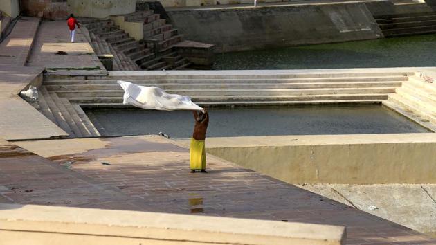 A man dries his dhoti near Pushkar Lake in Pushkar, Rajasthan on July 2, 2018. (Himanshu Sharma / AFP)