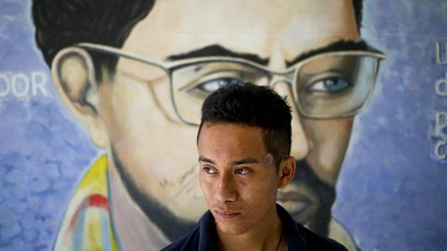 John Cerna poses for a portrait by a mural of Carlos Fonseca, national hero and founder of the Sandinista National Liberation Front. A student from the National Engineering University, he has a scar on his left temple where a bullet grazed him. “We prefer to stay here. We feel safer than in the streets or in our homes where they come to terrorize us, kidnap us or kill us,” Cerna said. (Esteban Felix / AP)