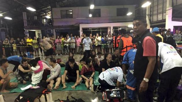 In this photo released by the Thailand Royal Police, rescued tourists from a boat that sank rest on a pier on Thursday in Thailand’s Phuket.(AP Photo)