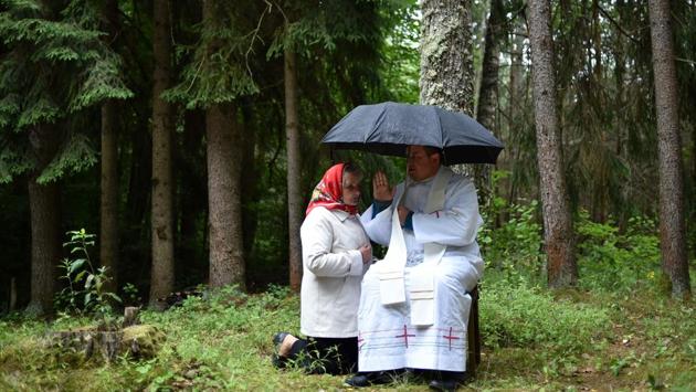 A Catholic priest hears a confession during the annual celebration of ‘Icon of the Mother of Perpetual Help’ in the forest near the village of Dubok, some 180 km northwest of Minsk, Belarus. (Sergei Gapon / AFP)