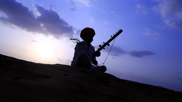 A Rajasthani man plays a “Ravanahatha” (traditional stringed instrument) in the desert of Pushkar, Rajasthan on July 4, 2018. (Himanshu Sharma / AFP)