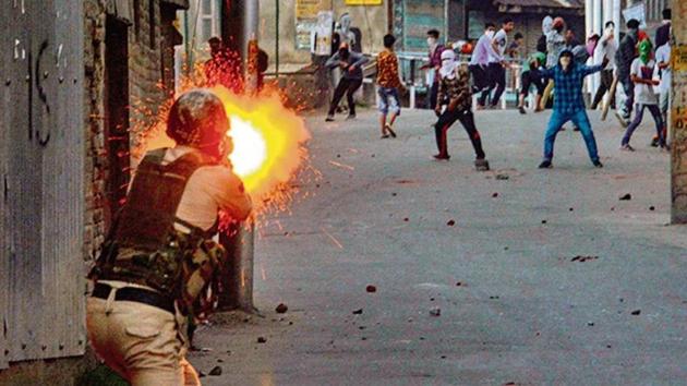 A policeman fires a tear gas shell towards the protesters hurling stones at forces in Srinagar on Saturday. PTI(PTI) A policeman fires a tear gas shell towards the protesters hurling stones at forces in Srinagar on Saturday. PTI(PTI)