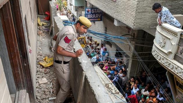 A police man stands in the balcony of the house, where 11 members of a family were found hanging from an iron grill, in Burari area of New Delhi.(PTI Photo)