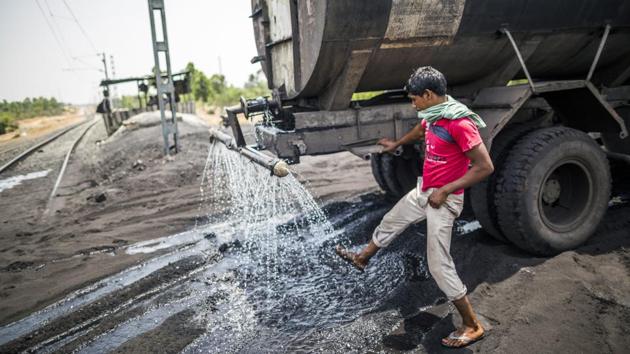 A man cleans up as a tanker sprays water at the Tori Siding. Operations at the Tori-Shivpur line allow Central Coalfields Ltd. (CCL) to finally ramp up production at these two mines as well as begin output at Chandragupta and Sanghamitra blocks in North Karanpura area. (Prashanth Vishwanathan / Bloomberg) A man cleans up as a tanker sprays water at the Tori Siding. Operations at the Tori-Shivpur line allow Central Coalfields Ltd. (CCL) to finally ramp up production at these two mines as well as begin output at Chandragupta and Sanghamitra blocks in North Karanpura area. (Prashanth Vishwanathan / Bloomberg)