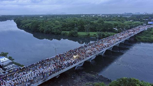 Around three lakh warkaris - followers of Sant Tukaram and Sant Dnyaneshwar - and two palkhis of Sant Tukaram Maharaj and Sant Dnyaneshwar arrived in Pune city on Saturday evening amid road diversions and heavy rainfall. Dressed in white dhoti-kurta and nine yard sarees, the warkaris carried steel utensils with them to avoid using plastic, displaying adherence to the plastic ban imposed by the state government. (Pratham Gokhale/HT Photo) Around three lakh warkaris - followers of Sant Tukaram and Sant Dnyaneshwar - and two palkhis of Sant Tukaram Maharaj and Sant Dnyaneshwar arrived in Pune city on Saturday evening amid road diversions and heavy rainfall. Dressed in white dhoti-kurta and nine yard sarees, the warkaris carried steel utensils with them to avoid using plastic, displaying adherence to the plastic ban imposed by the state government. (Pratham Gokhale/HT Photo)