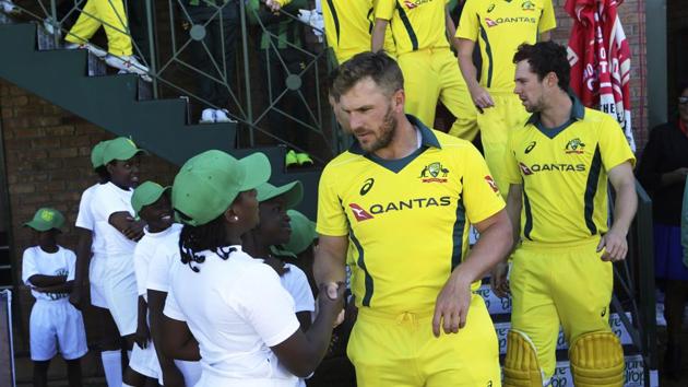 Australian captain Aaron Finch greets children on the final day of the T20 cricket match against Pakistan.(AP)