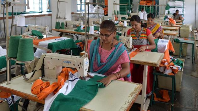 Employees of KGSS piece together a flag. Most workers, especially the women -- who also manage their households -- have rarely travelled outside their local districts. But Koti, the supervisor, says that knowing that their handiwork goes far and wide goes some way to compensating for this. (Manjunath Kiran / AFP)
