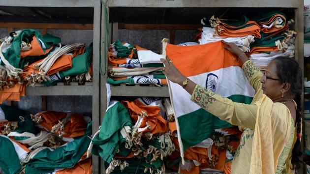 An employee checks finished national flags at Production Centre in Bengeri. “We can’t go outside to different places but the flags we make go all over the world and I feel proud to see everyone saluting them,” Koti said. (Manjunath Kiran / AFP)