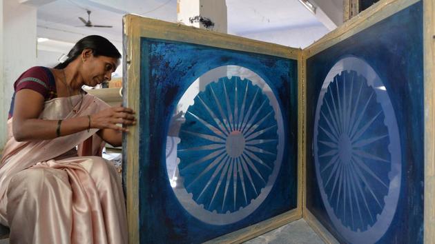 An employee checks a screen print for the central strip of the national flag in Bengeri. The guidelines in the national flag code of India and from the Bureau of Indian Standards are strict, covering everything from the exact shades to the stitching size. (Manjunath Kiran / AFP)