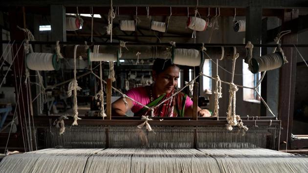 The female employees perform all the intricate parts of the process such as spinning the cotton and weaving the thread into cloth on foot-powered looms. Their flags hang at all official events and government buildings, at Indian embassies across the world, as well as at schools, village halls and on official cars. (Manjunath Kiran / AFP)