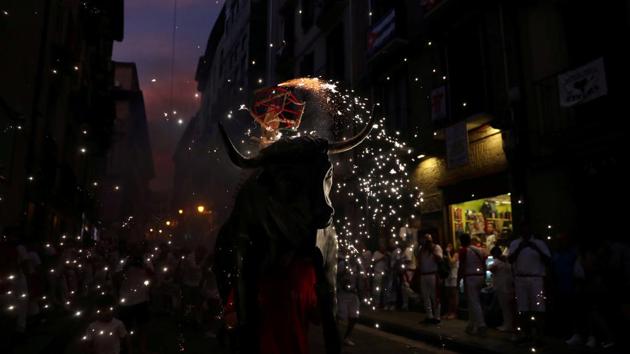 Revellers run next to the Fire Bull, a man carrying a bull figure packed with fireworks. This festival was immortalized by American Nobel Literature Prize winner Ernest Hemingway in his 1926 novel “The Sun Also Rises.” (Susana Vera / REUTERS) Revellers run next to the Fire Bull, a man carrying a bull figure packed with fireworks. This festival was immortalized by American Nobel Literature Prize winner Ernest Hemingway in his 1926 novel “The Sun Also Rises.” (Susana Vera / REUTERS)