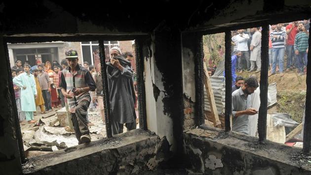 Kashmiri villagers inspect the damaged house where militants were hiding during an encounter at Kundalan village in Shopian.(Waseem Andrabi/HT Photo)