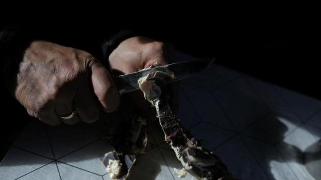 Sara cuts dried reindeer meat. In Norway, the government is offering exploration licences ever further north, in areas covered by winter sea ice until recent decades. Some reindeer herders see the influx of workers as a potential new market for their meat, but say companies rarely buy enough. (Stoyan Nenov / REUTERS)