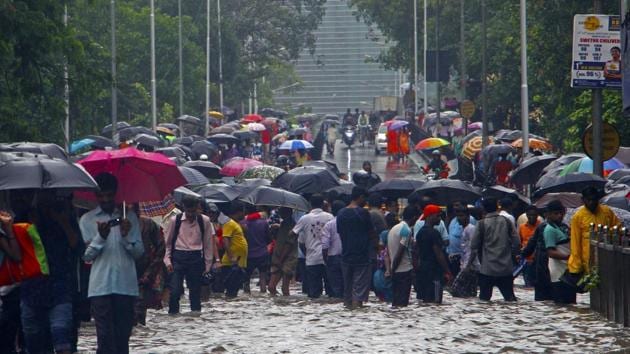 People wade through waterlogged road near Parel bridge in Mumbai, on Tuesday, July 10, 2018.(HT Photo/ Hemanshi Kamani)