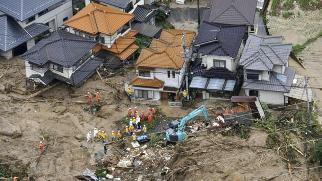 Rescue workers are seen next to houses damaged by a landslide following heavy rain in Hiroshima. In the Mabi district of Kurashiki, the water left behind a fine yellow silt that has transformed the area into moonscape. (Kyodo via REUTERS) Rescue workers are seen next to houses damaged by a landslide following heavy rain in Hiroshima. In the Mabi district of Kurashiki, the water left behind a fine yellow silt that has transformed the area into moonscape. (Kyodo via REUTERS)