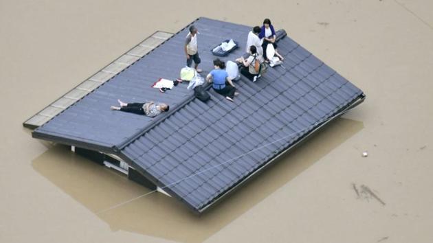 An aerial view shows local residents seen on the roof of submerged house at a flooded area as they wait for a rescue in Kurashiki, southern Japan on July 7. (Kyodo/via REUTERS) An aerial view shows local residents seen on the roof of submerged house at a flooded area as they wait for a rescue in Kurashiki, southern Japan on July 7. (Kyodo/via REUTERS)