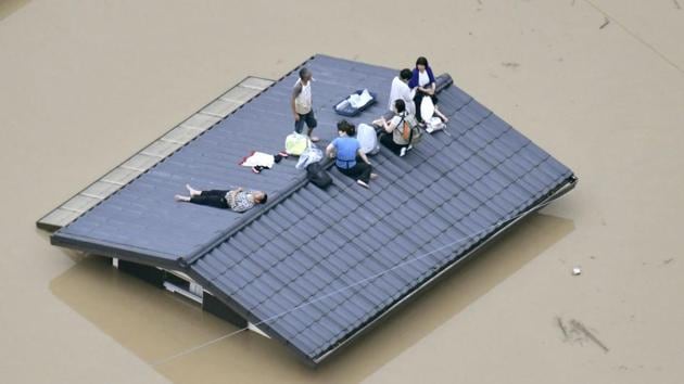 An aerial view shows local residents seen on the roof of submerged house in Kurashiki. Some homes were smashed, while others were tilting precariously. Rivers overflowed, turning towns into lakes and leaving dozens of people stranded on rooftops. Military paddle boats and helicopters brought people to the ground. (Kyodo via REUTERS) An aerial view shows local residents seen on the roof of submerged house in Kurashiki. Some homes were smashed, while others were tilting precariously. Rivers overflowed, turning towns into lakes and leaving dozens of people stranded on rooftops. Military paddle boats and helicopters brought people to the ground. (Kyodo via REUTERS)