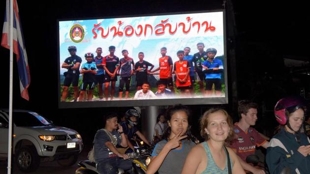 Motorists pass a billboard with a photograph showing members of the Thai Wild Boar football team and their coach with a message "welcome home brothers" in Chiang Rai on Tuesday. (AFP) Motorists pass a billboard with a photograph showing members of the Thai Wild Boar football team and their coach with a message "welcome home brothers" in Chiang Rai on Tuesday. (AFP)