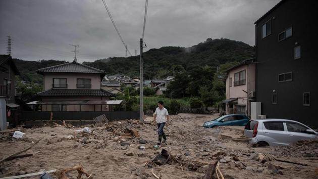A man walks past a devastated street during floods in Saka. The government has set up a task force to speed up deliveries of supplies and other support for evacuation centers and residents in the region, but disrupted roads and other ground transportation have delayed shipment, raising concerns of shortages. (Martin Bureau / AFP) A man walks past a devastated street during floods in Saka. The government has set up a task force to speed up deliveries of supplies and other support for evacuation centers and residents in the region, but disrupted roads and other ground transportation have delayed shipment, raising concerns of shortages. (Martin Bureau / AFP)