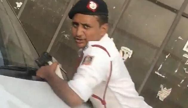 A traffic constable clings on to the bonnet of an SUV that rammed into a police barricade on Naraina flyover.(HT Video Grab)