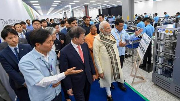 Prime Minister Narendra Modi with South Korean president Moon Jae-in and other delegates take a tour of the world's largest mobile phone manufacturing facility after its inauguration ceremony, in Noida on Monday.(PTI Photo)