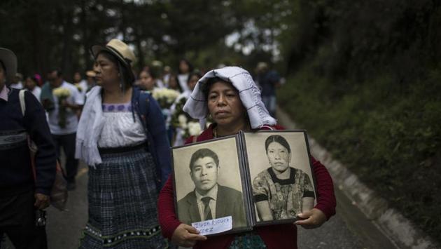 Marivel Yolanda Rucuch carries portraits of her father Juan Rucuch and aunt Virgilia Quina who were disappeared in the 1980's, allegedly by the army, during the funeral procession for 172 unidentified people. In this small rural town, the anonymous remains of some of the tens of thousands who disappeared during Guatemala’s long and bloody civil war can finally rest in peace. (Rodrigo Abd / AP) Marivel Yolanda Rucuch carries portraits of her father Juan Rucuch and aunt Virgilia Quina who were disappeared in the 1980's, allegedly by the army, during the funeral procession for 172 unidentified people. In this small rural town, the anonymous remains of some of the tens of thousands who disappeared during Guatemala’s long and bloody civil war can finally rest in peace. (Rodrigo Abd / AP)