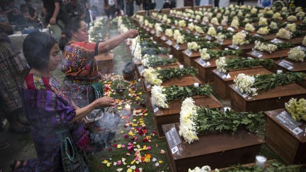 Women burn incense before the remains during a funeral ceremony in San Juan Comalapa, Guatemala. It is through art that “we can reclaim the victims’ existence” and educate young people born after the war, said Uriela Cumes, one of the Kakchikel artists involved in the project. (Rodrigo Abd / AP) Women burn incense before the remains during a funeral ceremony in San Juan Comalapa, Guatemala. It is through art that “we can reclaim the victims’ existence” and educate young people born after the war, said Uriela Cumes, one of the Kakchikel artists involved in the project. (Rodrigo Abd / AP)