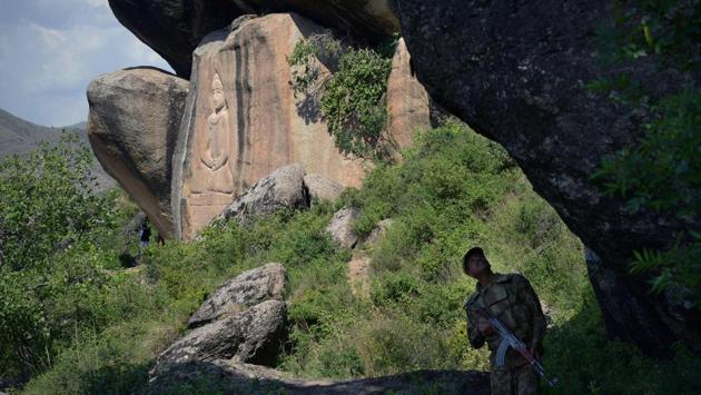 A Pakistani soldier looks up while walking past the Buddha of Swat. The holy figure, depicted in a lotus position at the base of a granite cliff in northern Pakistan, was severely damaged by Islamist insurgents in an echo of the Afghan Taliban’s complete destruction of its more imposing counterparts at Bamiyan in 2001. (Abdul Majeed / AFP) A Pakistani soldier looks up while walking past the Buddha of Swat. The holy figure, depicted in a lotus position at the base of a granite cliff in northern Pakistan, was severely damaged by Islamist insurgents in an echo of the Afghan Taliban’s complete destruction of its more imposing counterparts at Bamiyan in 2001. (Abdul Majeed / AFP)