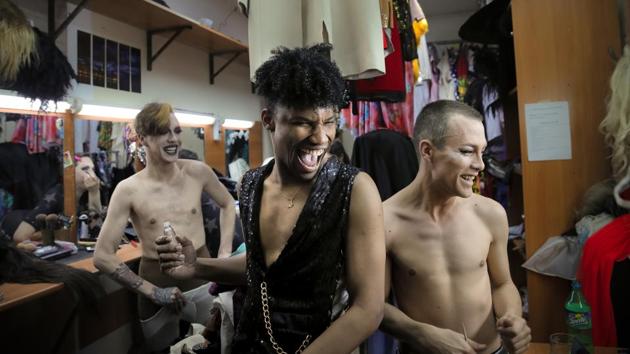 Choosing from hundreds of shades of lip tones and eye colour, pulling up leotards with tattooed arms, they design a new persona. Star Vasha squeezes into a shimmering yellow gown, wrists draped in strings of pearls. (Vadim Ghirda / AP) Choosing from hundreds of shades of lip tones and eye colour, pulling up leotards with tattooed arms, they design a new persona. Star Vasha squeezes into a shimmering yellow gown, wrists draped in strings of pearls. (Vadim Ghirda / AP)
