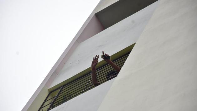 The stalker is seen gesturing from the flat where he allegedly held hostage a woman he claims he loves.(HT photo)