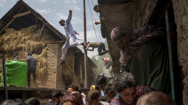 Kashmiri villagers inspecting a house damaged in a gun battle flee after hearing rumors of Indian army soldiers returning back to the site, which turned out to be false, in Kundalan village, some 60 Kilometres south of Srinagar on July, 10, 2018. (Dar Yasin / AP) Kashmiri villagers inspecting a house damaged in a gun battle flee after hearing rumors of Indian army soldiers returning back to the site, which turned out to be false, in Kundalan village, some 60 Kilometres south of Srinagar on July, 10, 2018. (Dar Yasin / AP)