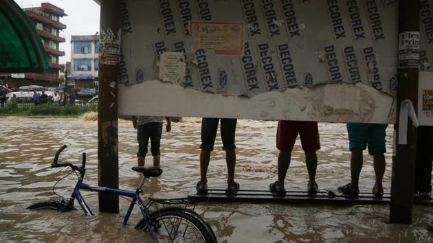 Nepalese stand atop a bench in a flooded area in Bhaktapur, Nepal. The flooding was caused by overflowing of the Hanumante River following heavy rain. (Niranjan Shrestha / AP) Nepalese stand atop a bench in a flooded area in Bhaktapur, Nepal. The flooding was caused by overflowing of the Hanumante River following heavy rain. (Niranjan Shrestha / AP)