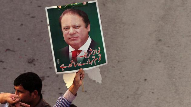 A supporter of the Pakistan Muslim League - Nawaz (PML-N) holds a portrait as he march towards the airport with others to welcome ousted Prime Minister Nawaz Sharif and his daughter Maryam, in Lahore.(Reuters Photo)
