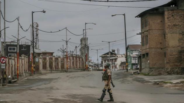 A soldier walks on a deserted road during curfew in Srinagar, Kashmir.(AP Photo)