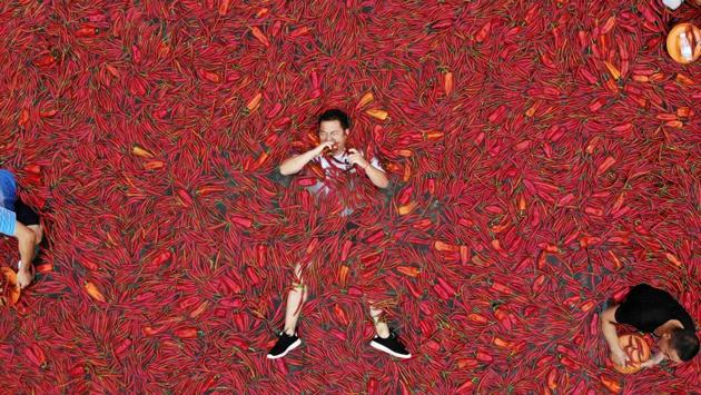 A contestant takes part in a chilli pepper eating competition in Ningxiang in China's central Hunan province. The winner of the contest ate 50 chilli peppers in one minute. (AFP) A contestant takes part in a chilli pepper eating competition in Ningxiang in China's central Hunan province. The winner of the contest ate 50 chilli peppers in one minute. (AFP)