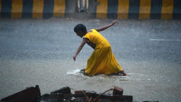 A girl walks on a road during heavy rain showers in Allahabad on July 11, 2018. (Sanjay Kanojia / AFP) A girl walks on a road during heavy rain showers in Allahabad on July 11, 2018. (Sanjay Kanojia / AFP)