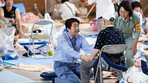 Japan's Prime Minister Shinzo Abe (C) visits a shelter for people affected by the recent flooding in Mabi, Okayama prefecture. (Martin Bureau / AFP) Japan's Prime Minister Shinzo Abe (C) visits a shelter for people affected by the recent flooding in Mabi, Okayama prefecture. (Martin Bureau / AFP)