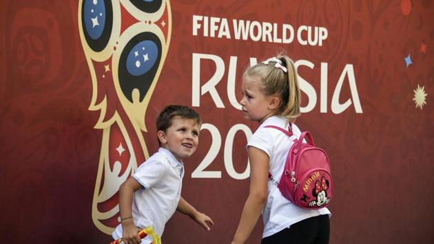Children play in front of a banner of the FIFA World Cup 2018 ahead of the final in Moscow.(AFP)