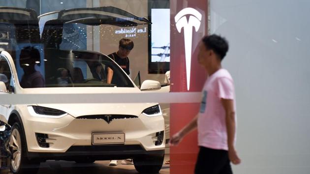 This file picture taken on July 4, 2018 shows a man visiting a Tesla showroom in Beijing.(AFP File Photo)