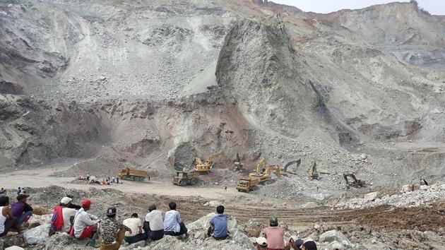 Local jade scavengers watch as authorities use backhoes to uncover bodies at the site of a landslide on May 4.(AP File Photo)