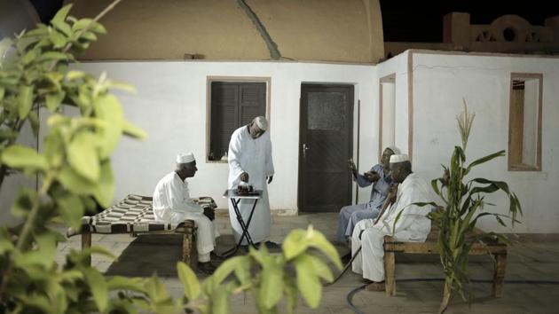 Men talk at a home in Wadi Karkar, a new complex under construction in the desert west of Lake Nasser.  In the decades since, Nubian towns — like many others in southern Egypt — have sunk into poverty. Many Nubians have moved to larger cities like Cairo, Alexandria or Aswan, searching for jobs. Customs have withered. The Nubian language is not taught in schools. (Nariman El-Mofty / AP) 