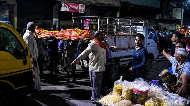 Men unload a dead body from a van at the Harishchandra ghat. Despite the importance of their ceremonial duty in Hindu funeral rites, the Doms hail from the bottom rungs of the Dalit community. All are engaged at some level in the cremation business -- maintaining fires in the ghat temples, arranging wood for the pyres or selling flowers and other ornaments for the ceremony. (Chandan Khanna / AFP) Men unload a dead body from a van at the Harishchandra ghat. Despite the importance of their ceremonial duty in Hindu funeral rites, the Doms hail from the bottom rungs of the Dalit community. All are engaged at some level in the cremation business -- maintaining fires in the ghat temples, arranging wood for the pyres or selling flowers and other ornaments for the ceremony. (Chandan Khanna / AFP)