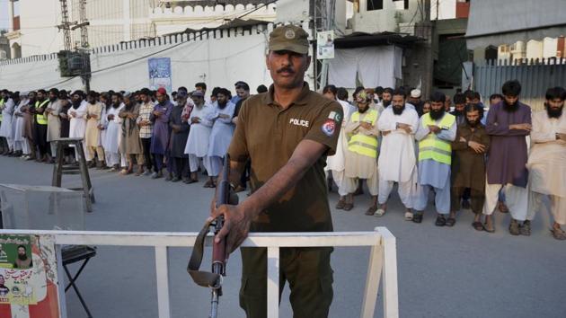 A Pakistani police officer stands guard while people offer funeral prayers in Lahore for the victims of a Friday suicide bombing in Mastung district of Baluchistan province, Pakistan that killed 128 people on July 15.(AP Photo) A Pakistani police officer stands guard while people offer funeral prayers in Lahore for the victims of a Friday suicide bombing in Mastung district of Baluchistan province, Pakistan that killed 128 people on July 15.(AP Photo)