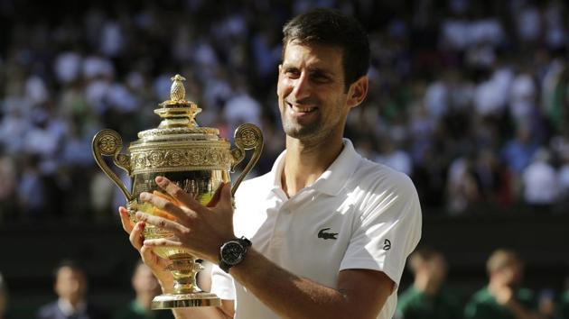 Novak Djokovic of Serbia holds the trophy after defeating Kevin Anderson of South Africa in the men's singles final at the Wimbledon tennis championships in London on Sunday.(AP)