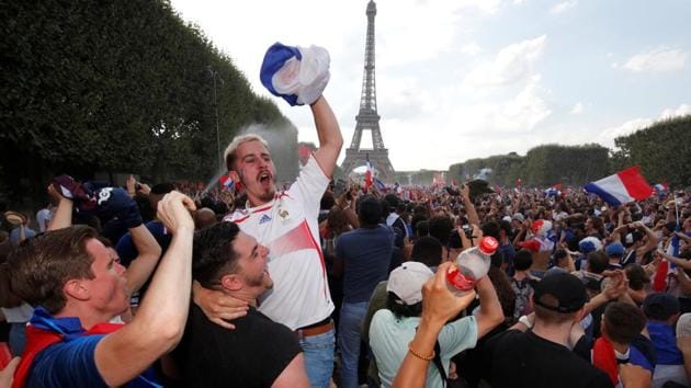 France fans celebrate in front of the Eiffel Tower after their team beat Croatia to win the FIFA World Cup after 20 years.(Reuters)