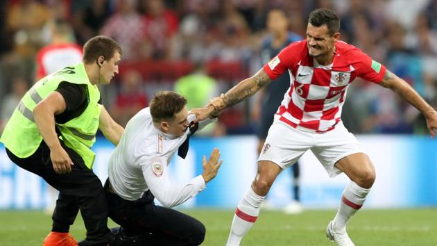 A steward apprehends a pitch invader while Croatia's Dejan Lovren looks on.(REUTERS)