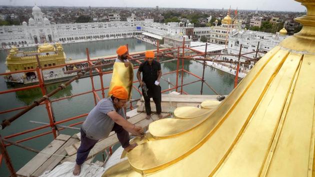Craftsmen fitting the gold plated pataras (sheets) on the central dome of deodi (entrance) of the Golden Temple in Amritsar on Sunday.(Sameer Sehgal) Craftsmen fitting the gold plated pataras (sheets) on the central dome of deodi (entrance) of the Golden Temple in Amritsar on Sunday.(Sameer Sehgal)