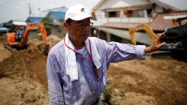 63-year-old Atsushi Yamashita, who lives next to the Odagawa and Takama Rivers, takes a break from removing mud and debris from his destroyed house. Local politicians had been working for years to change the flow of the Odagawa. The flood control project finally won approval in 2010 and construction was set to start this autumn. (Issei Kato / REUTERS) 