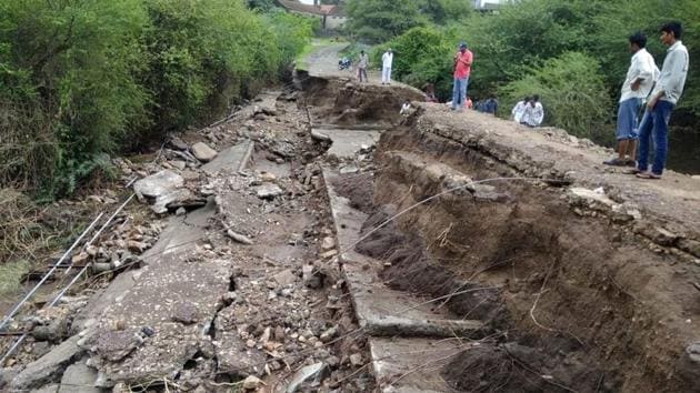 People walk through damage road after heavy rain in Sukhpur village of Junagadh in Gujarat on July 15, 2018. (PTI Photo) People walk through damage road after heavy rain in Sukhpur village of Junagadh in Gujarat on July 15, 2018. (PTI Photo)